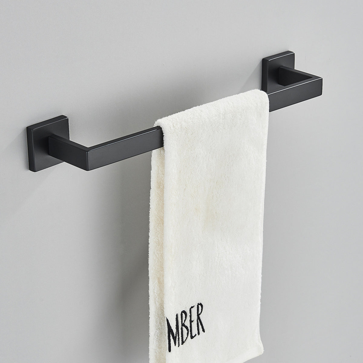 Toalheiro de barra em inox 304 preto fosco Shine com toalha branca pendurada.