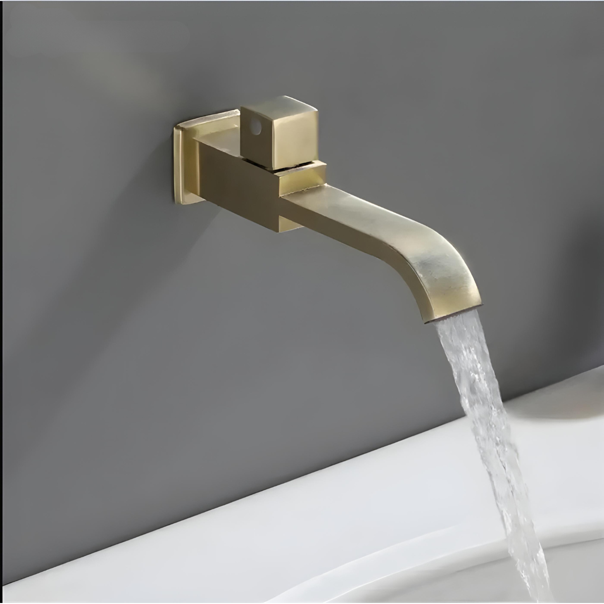 Torneira de parede para banheiro moderna Ottones em dourado fosco com água fluindo.