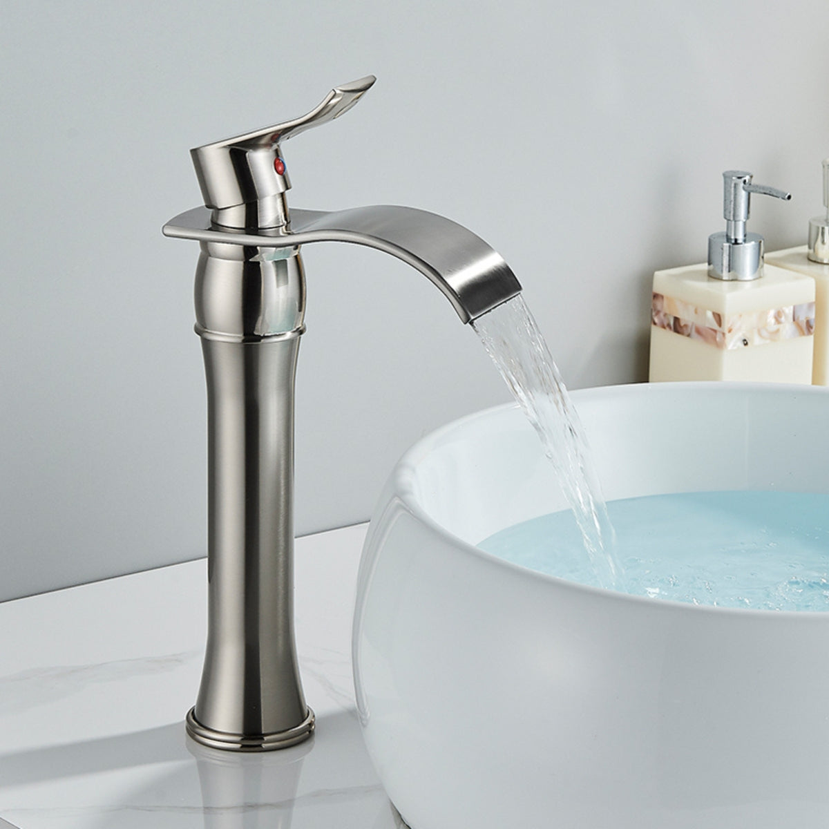 Torneira de banheiro monocomando bica alta em aço escovado da Homedeccori com efeito cascata.