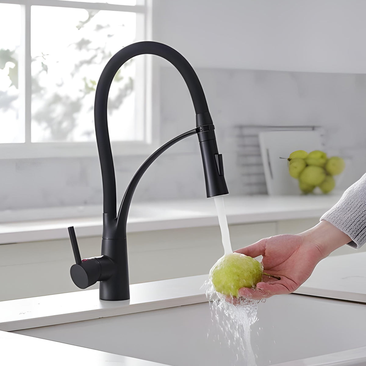 Torneira Gourmet Cozinha Monocomando Extensível Baikal preta lavando uma maçã na pia.