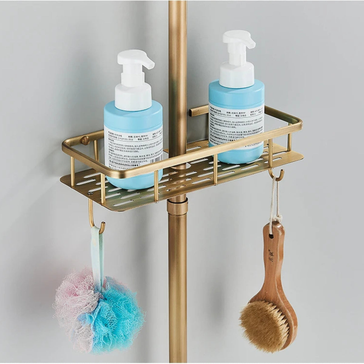 Prateleira de banho em bronze antigo da marca Homedeccori com frascos e acessórios.