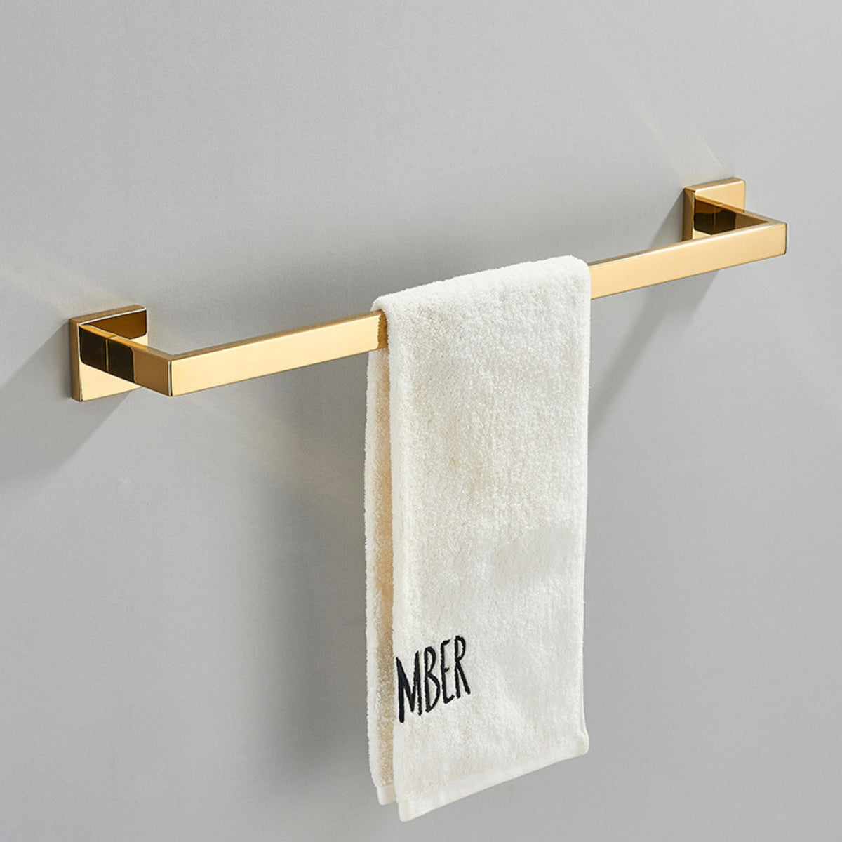Toalheiro de banheiro em inox dourado com toalha branca, linha Shine Homedeccori.