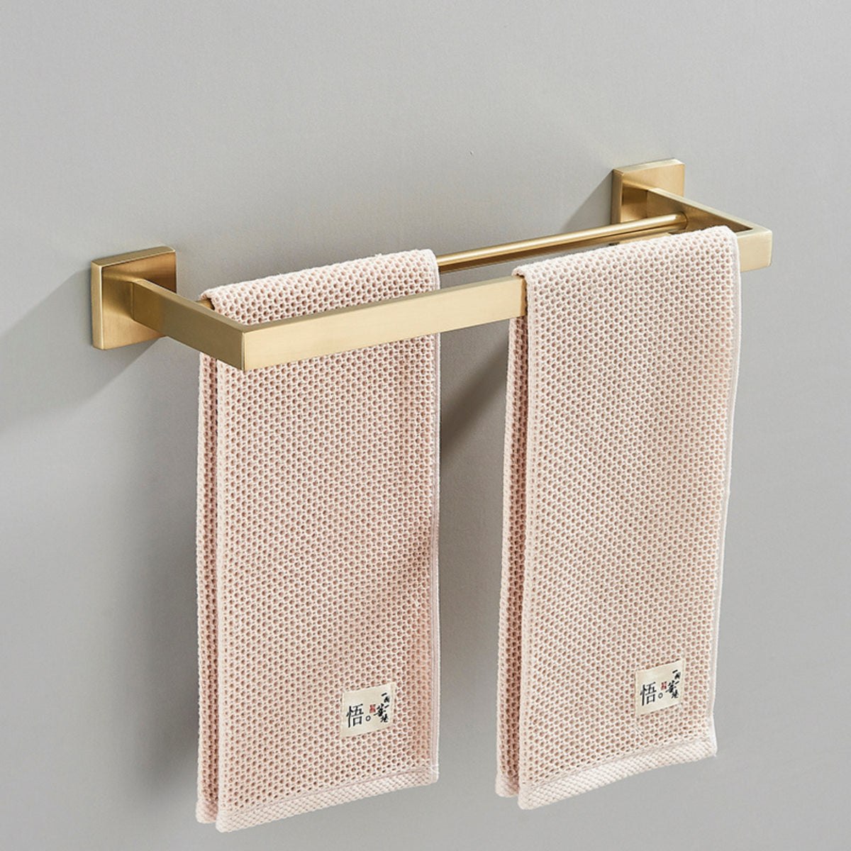 Porta toalhas duplo em aço inox dourado Homedeccori com toalhas rosa claro